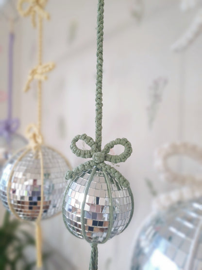 a green macrame disco mirror balls with bows